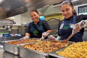 Food Services team preparing scratch-cooked pasta with meat sauce.