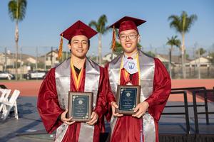 Two male graduates from La Serna High School pose and display their Board of Trustees award.