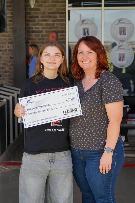 student receives his check from foundation members