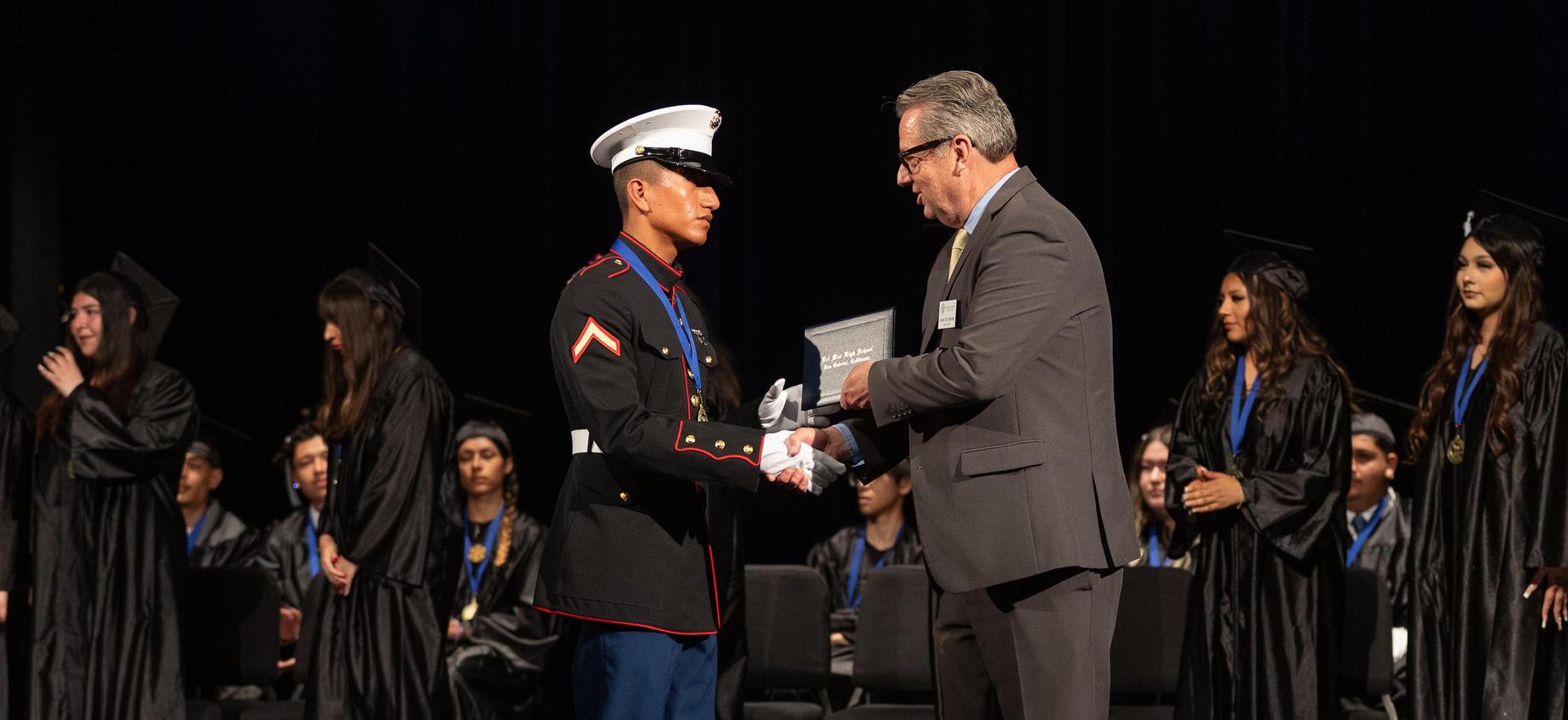 A military graduate receives an award during a ceremony.