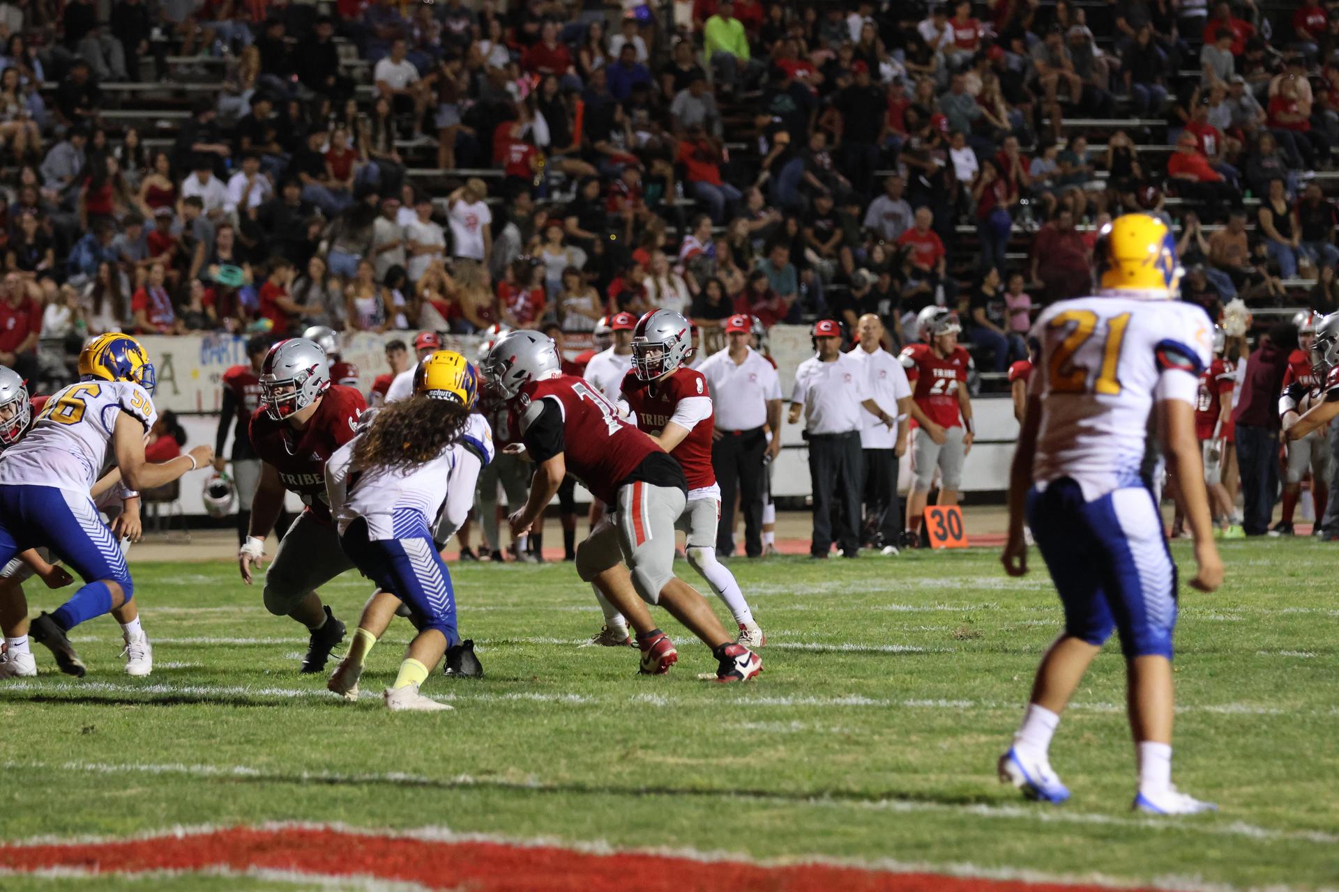 Varsity football players in action against Parlier 60