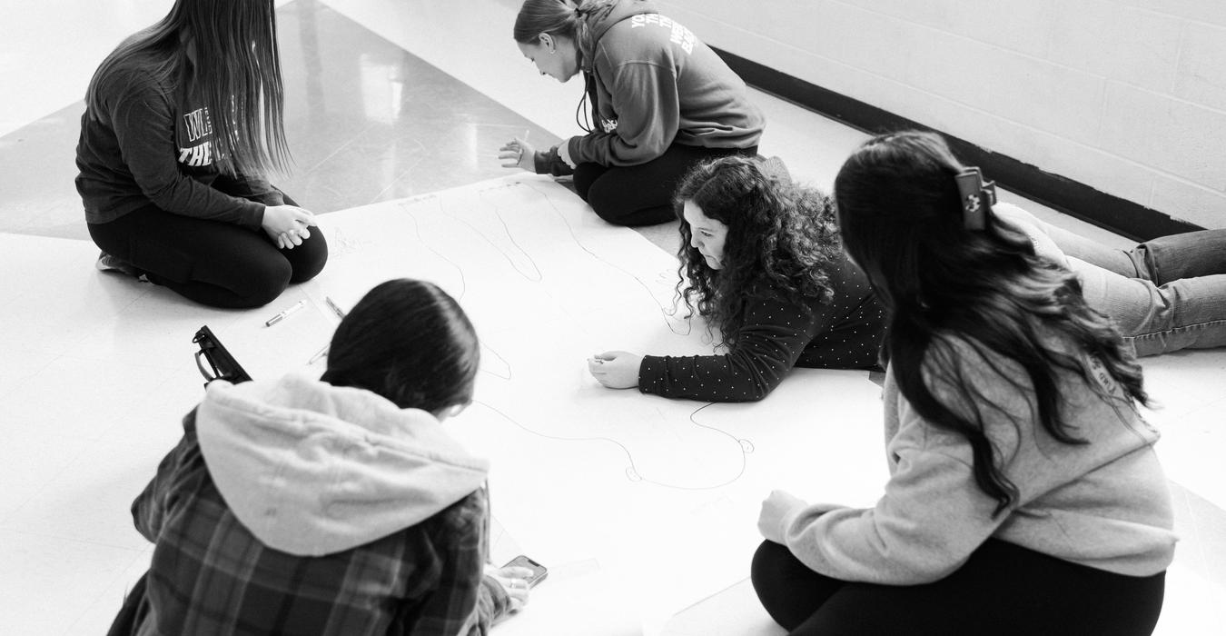Students working on a paper human diagram.