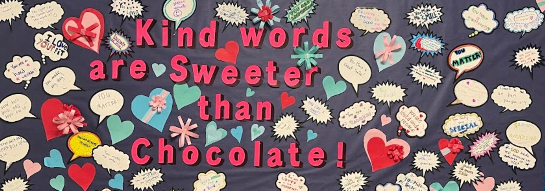 Colorful bulletin board with hearts and quotes promoting kindness.