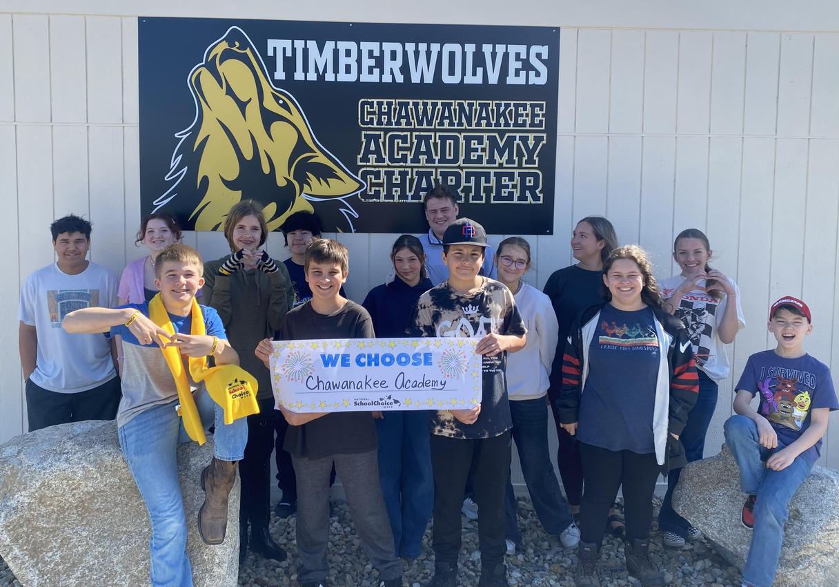 Group of students holding a sign that says 'We Choose Chawanakee Academy.'