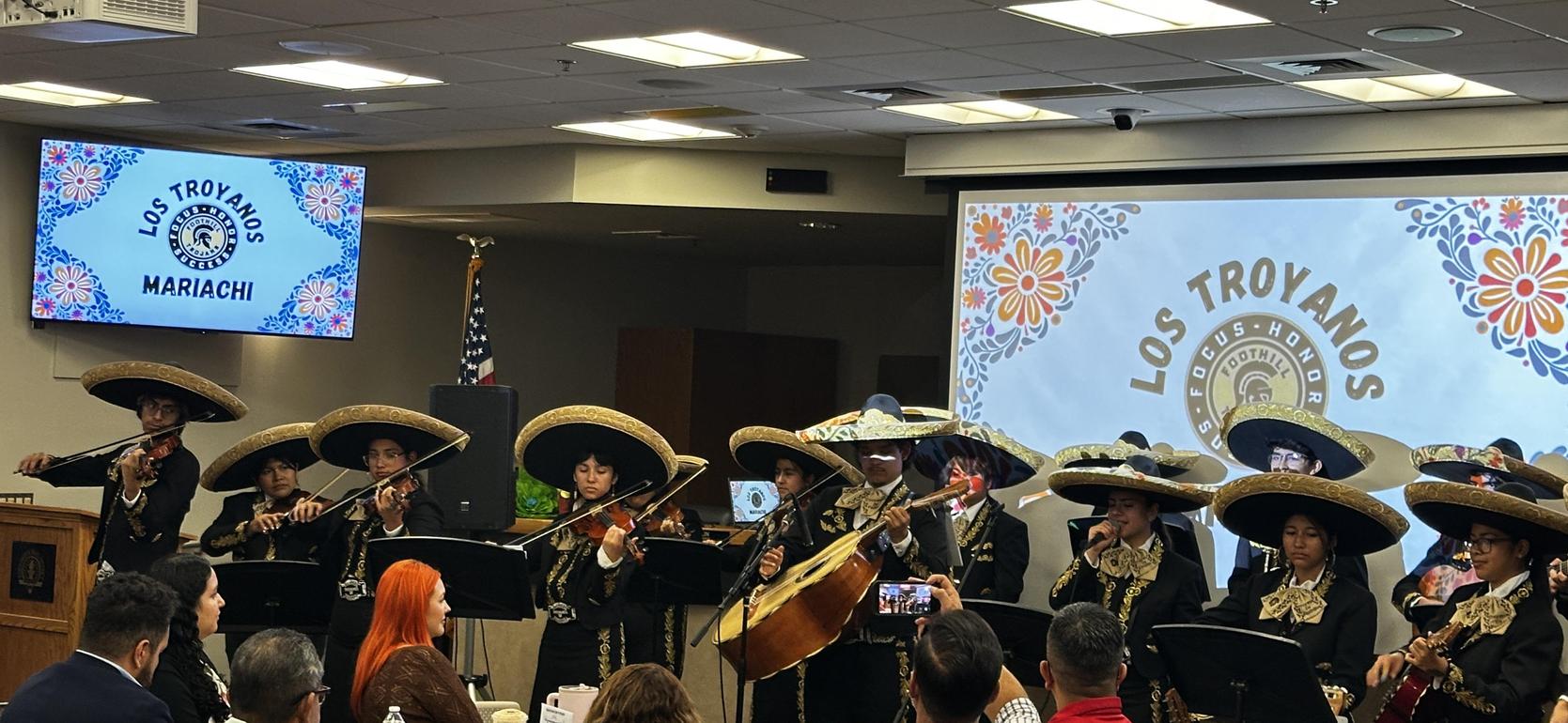 A mariachi group performing with traditional instruments and attire.