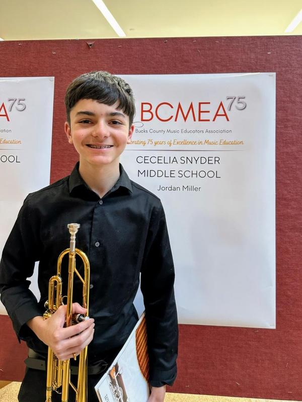 Image of a high school boy holding his trumpet