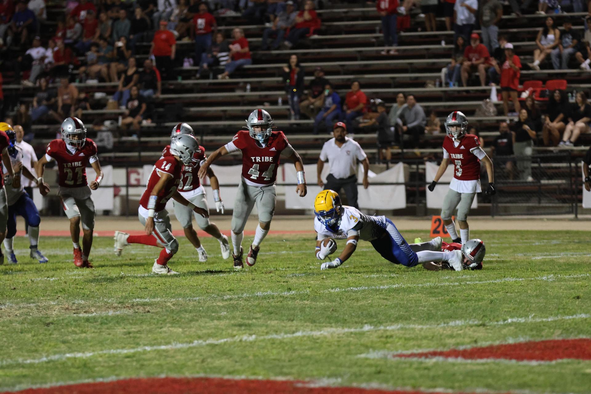 Varsity football players in action against Parlier 127