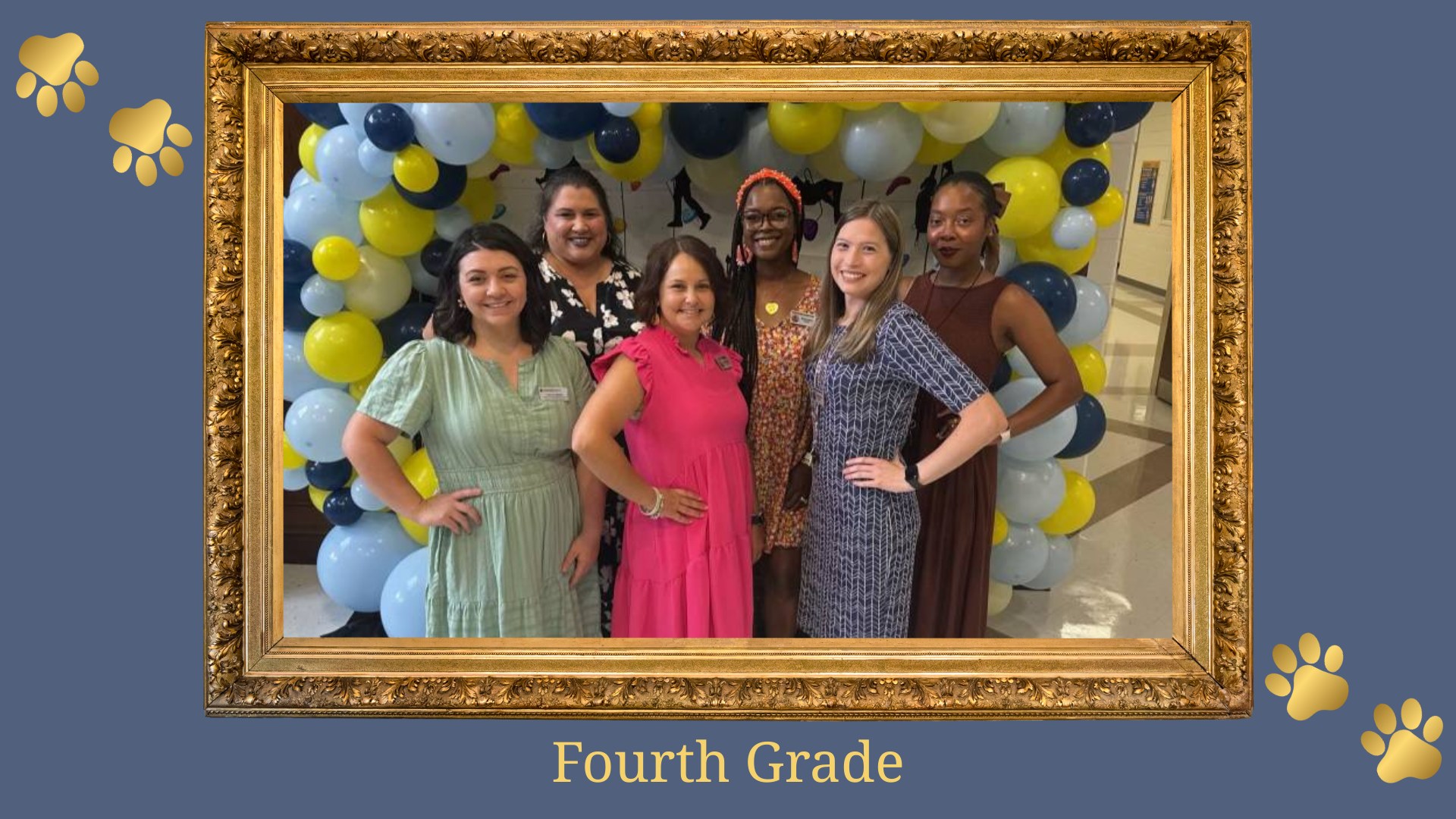 Six educators posing in front of a balloon arch marked for Fourth Grade.
