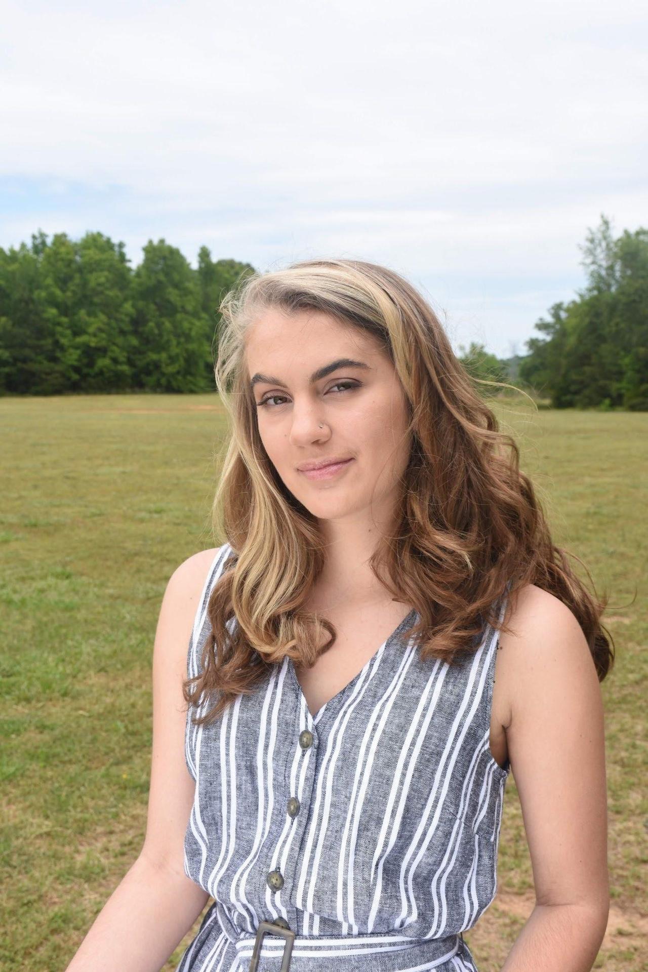 Image of Katie Karban. Brown hair, striped shirt, art teacher