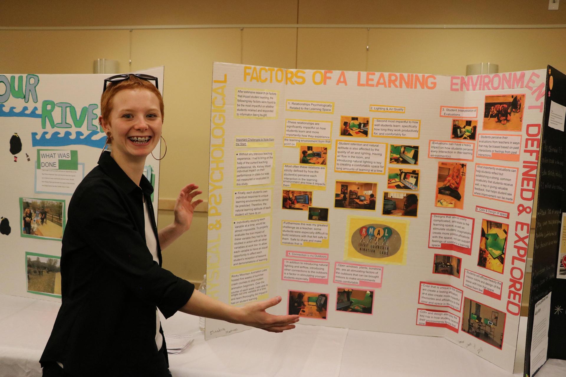 red haired girl smiles with a presentation