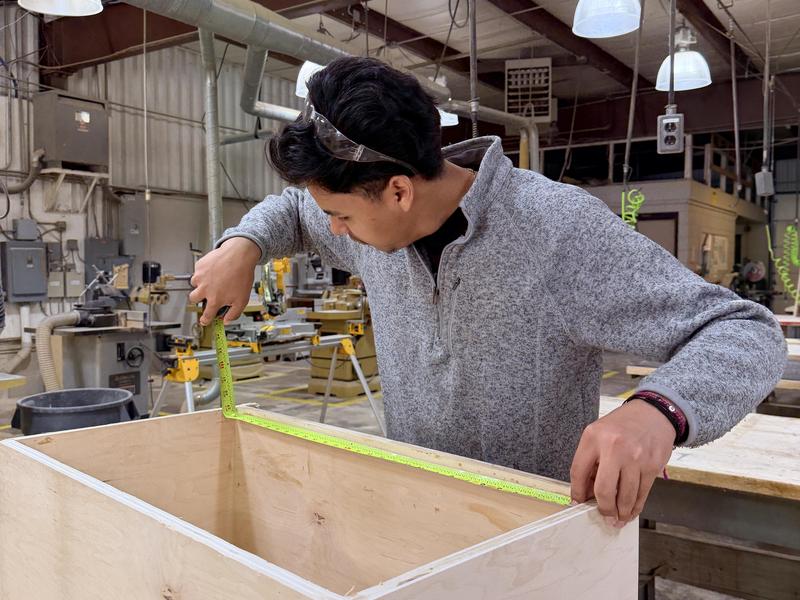 carpentry student measuring