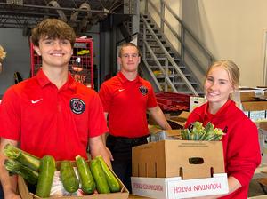 students smiling holding food boxes