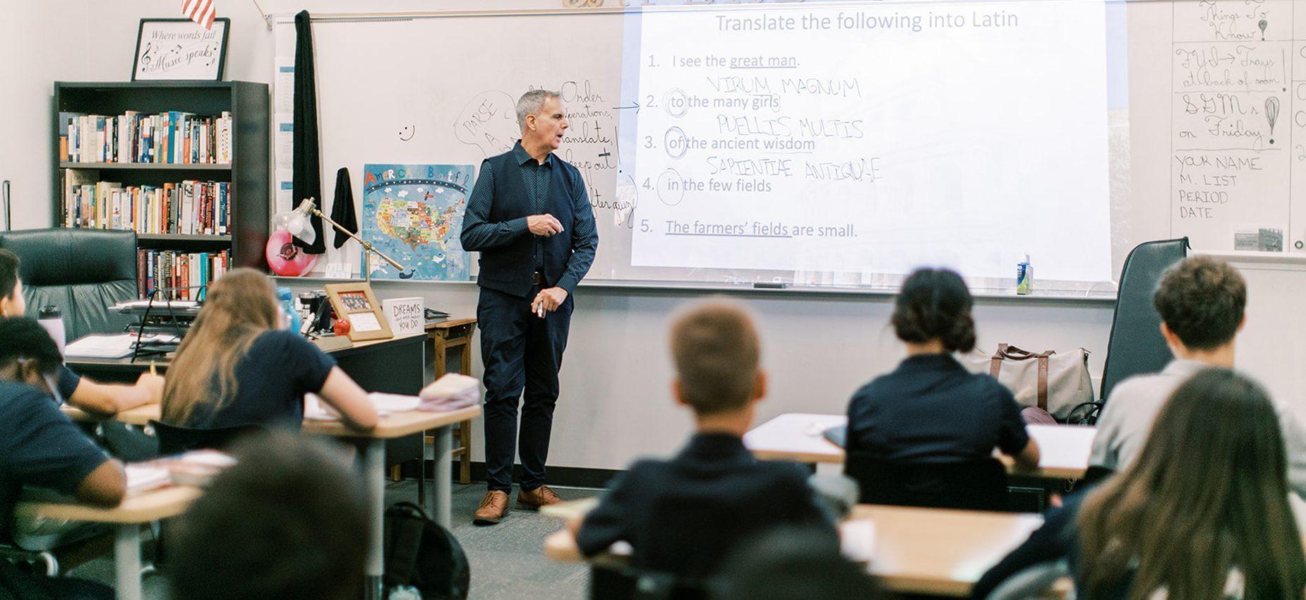 A teacher leads a Latin lesson as students listen