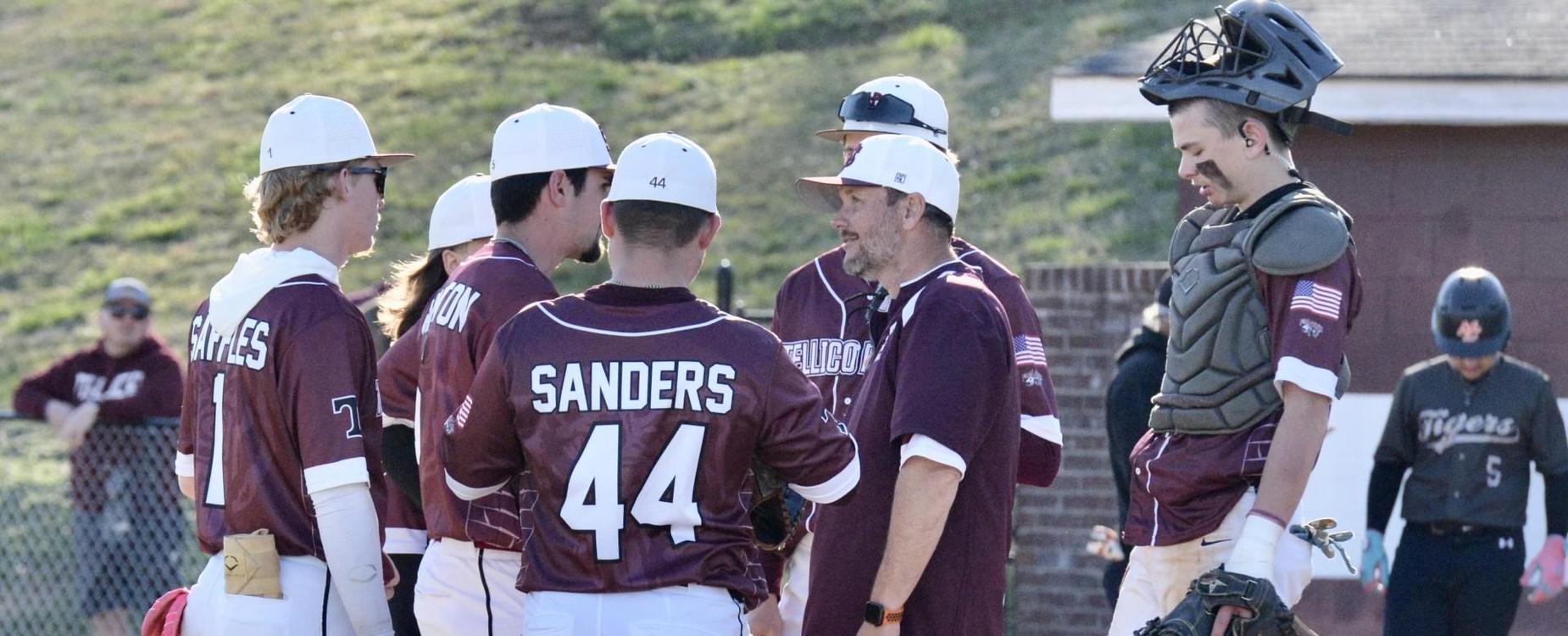 2024-25 baseball team huddled together on the field during a game.