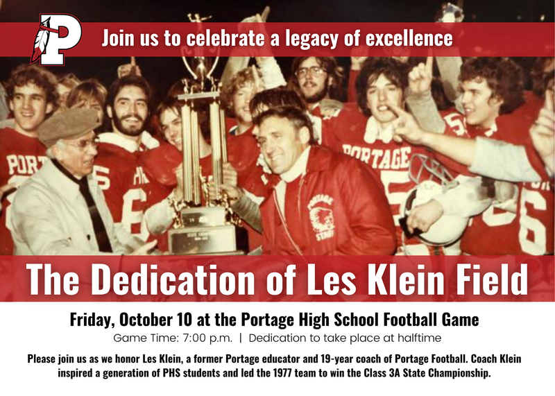 Group of football players celebrating with a trophy at a dedication event.