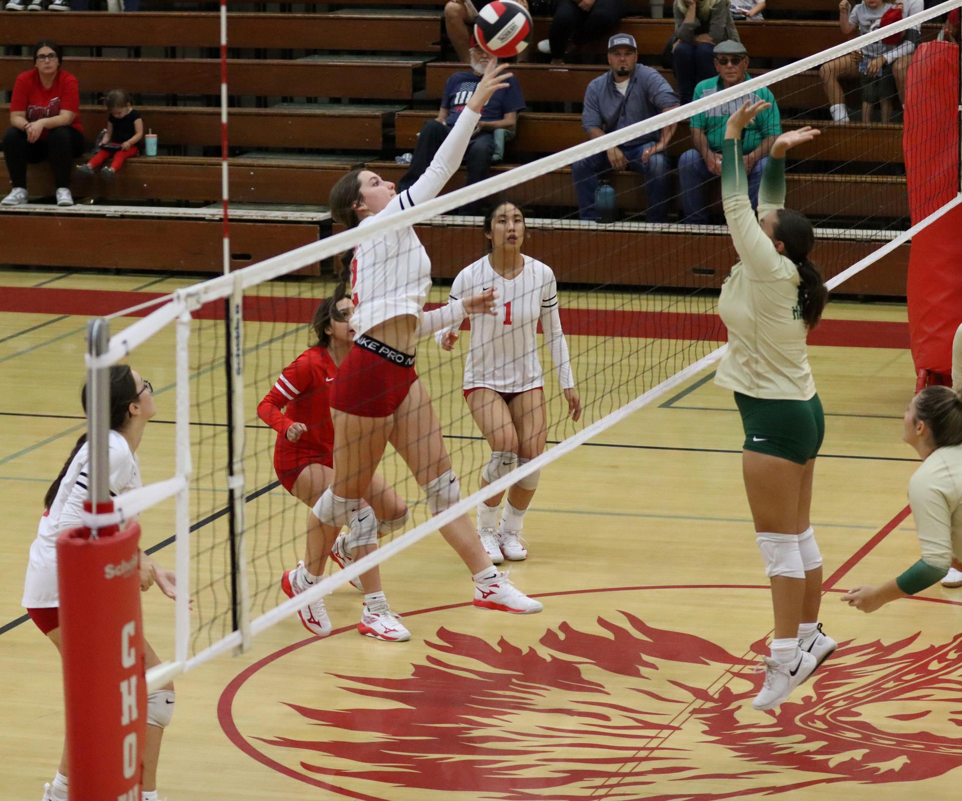 varsity volleyball players in action against liberty