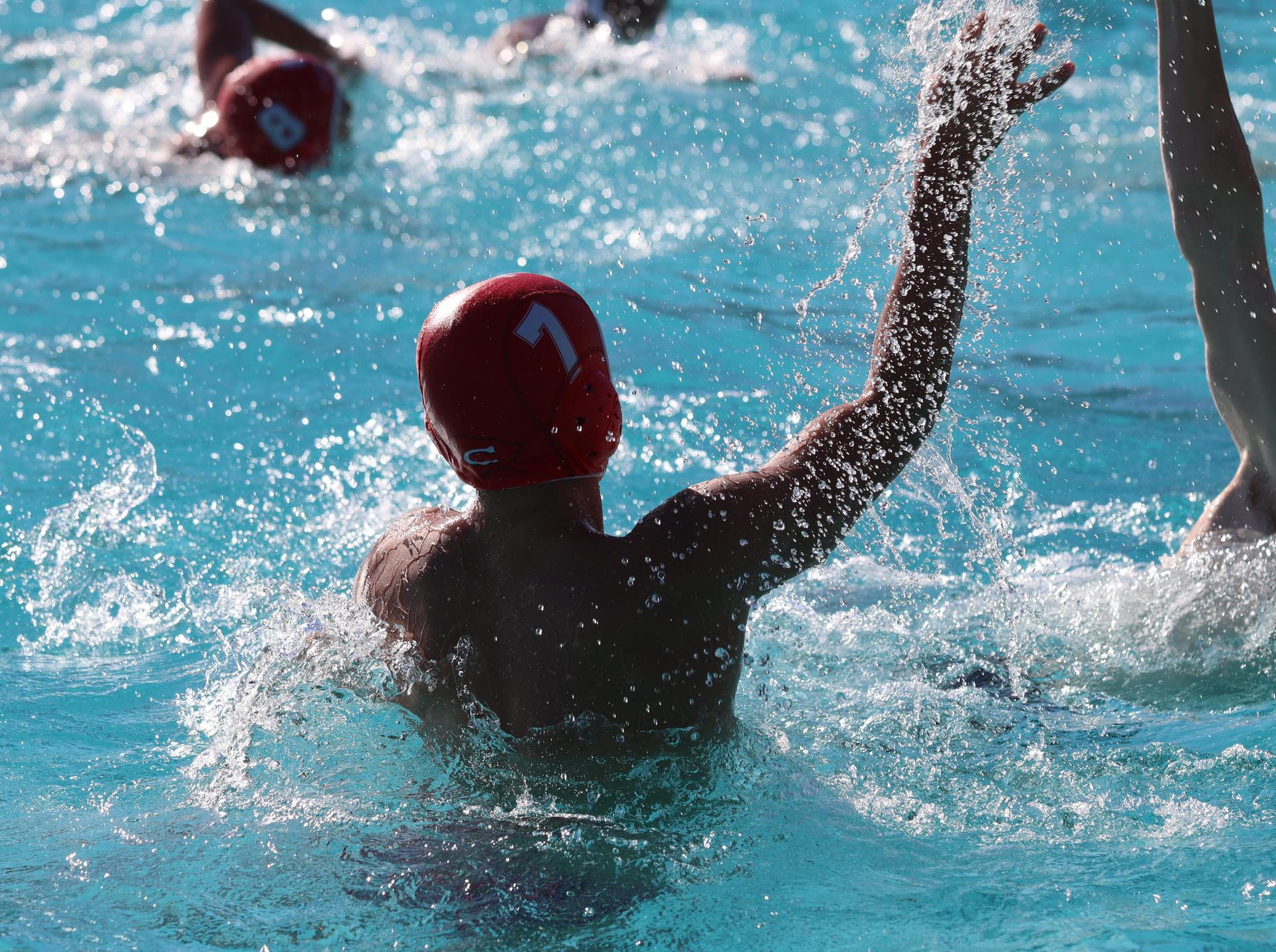 boys water polo players in action against hoover