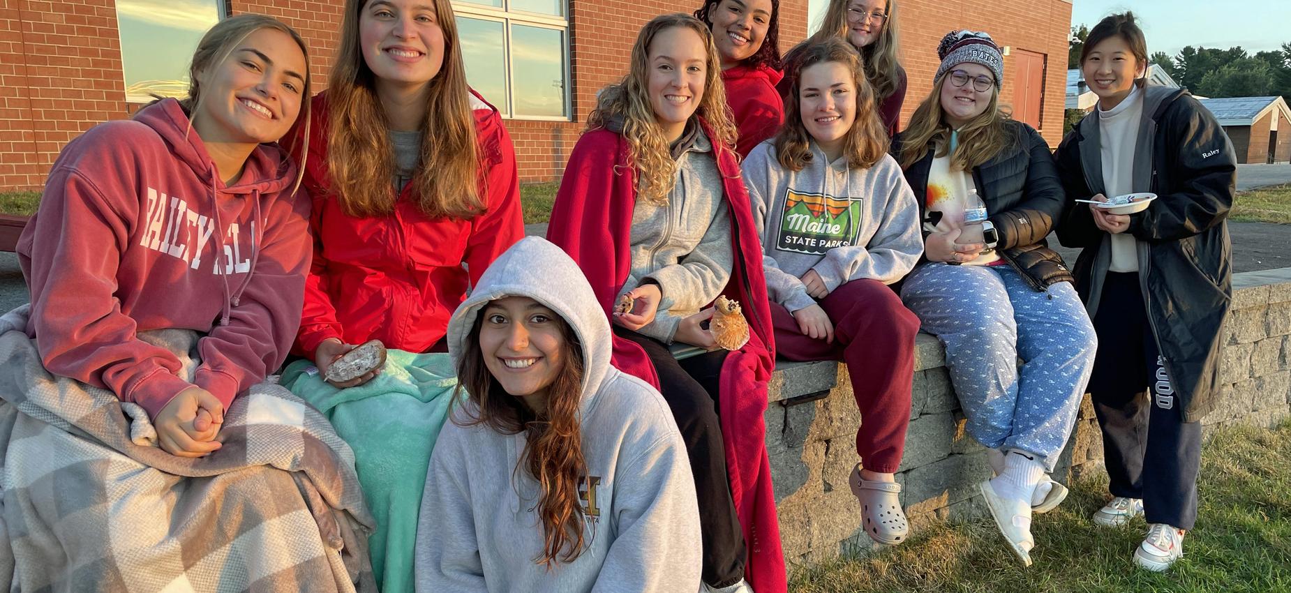 girls sitting on a wall
