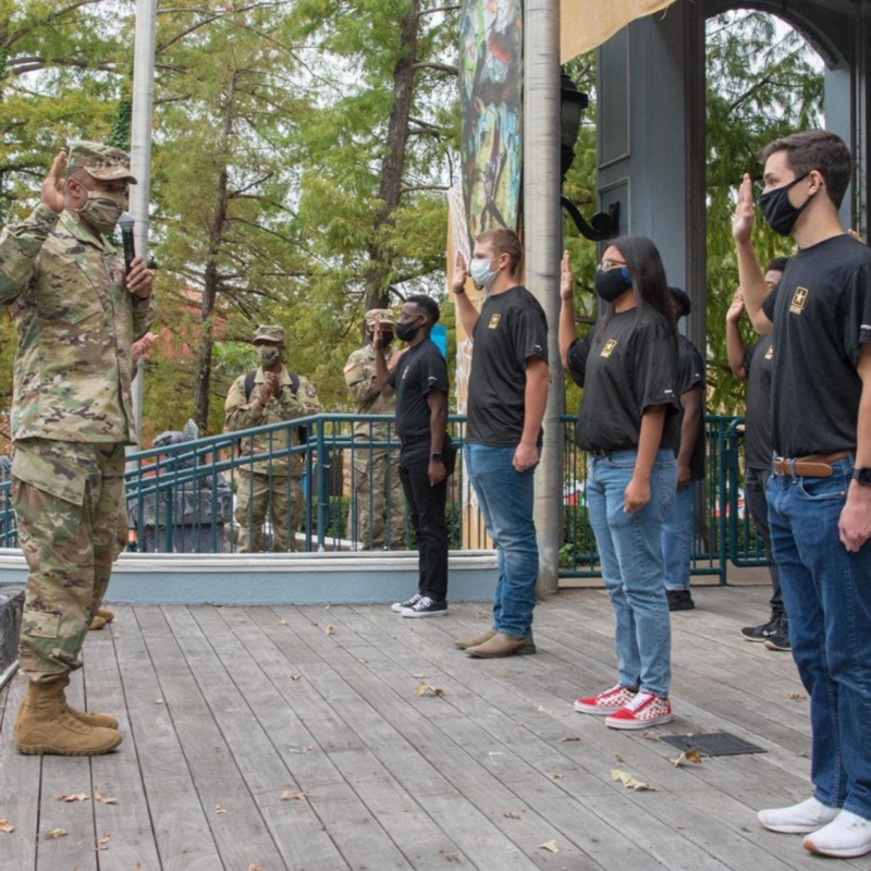 group of students standing before a uniformed officer getting sworn in to the US Army
