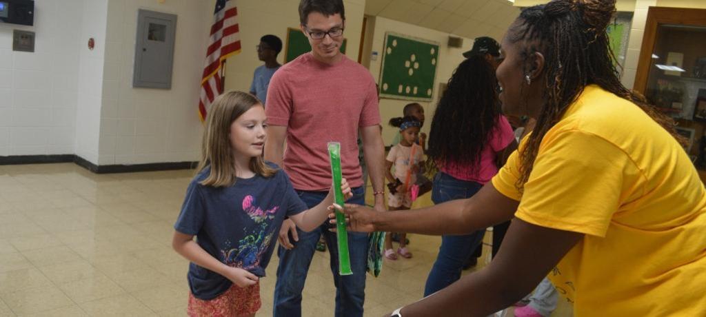 Assistant Principal hands girl a popsicle