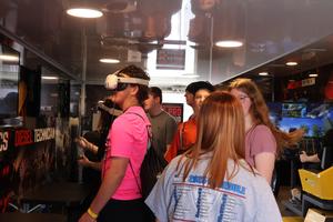 Seven students at the STEAM expo working with VR headsets.