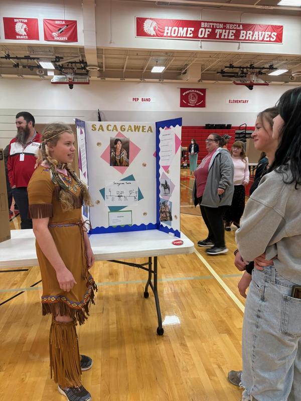 Child in a Native American costume presenting a project about Sacagawea.