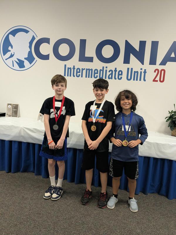 top 3 finishers from grades 4 and 5 stand together