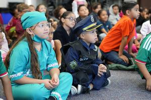 student dressed as surgeon and police officer sitting quietly in classroom