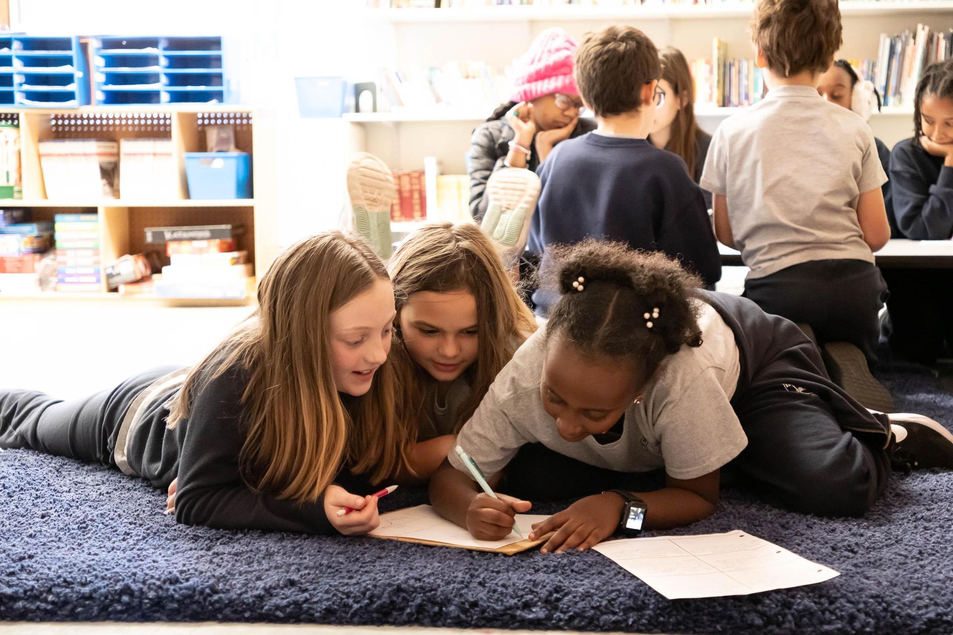 Students doing small group work on a rug 