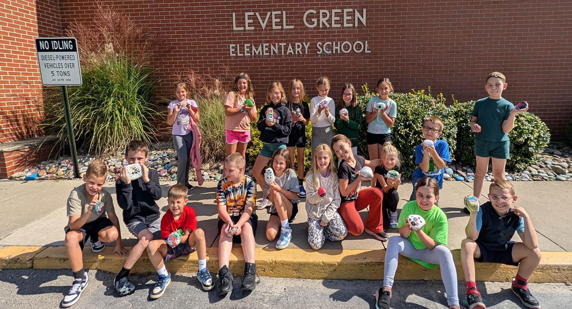 Students happily pose with painted rocks outside Level Green Elementary School.