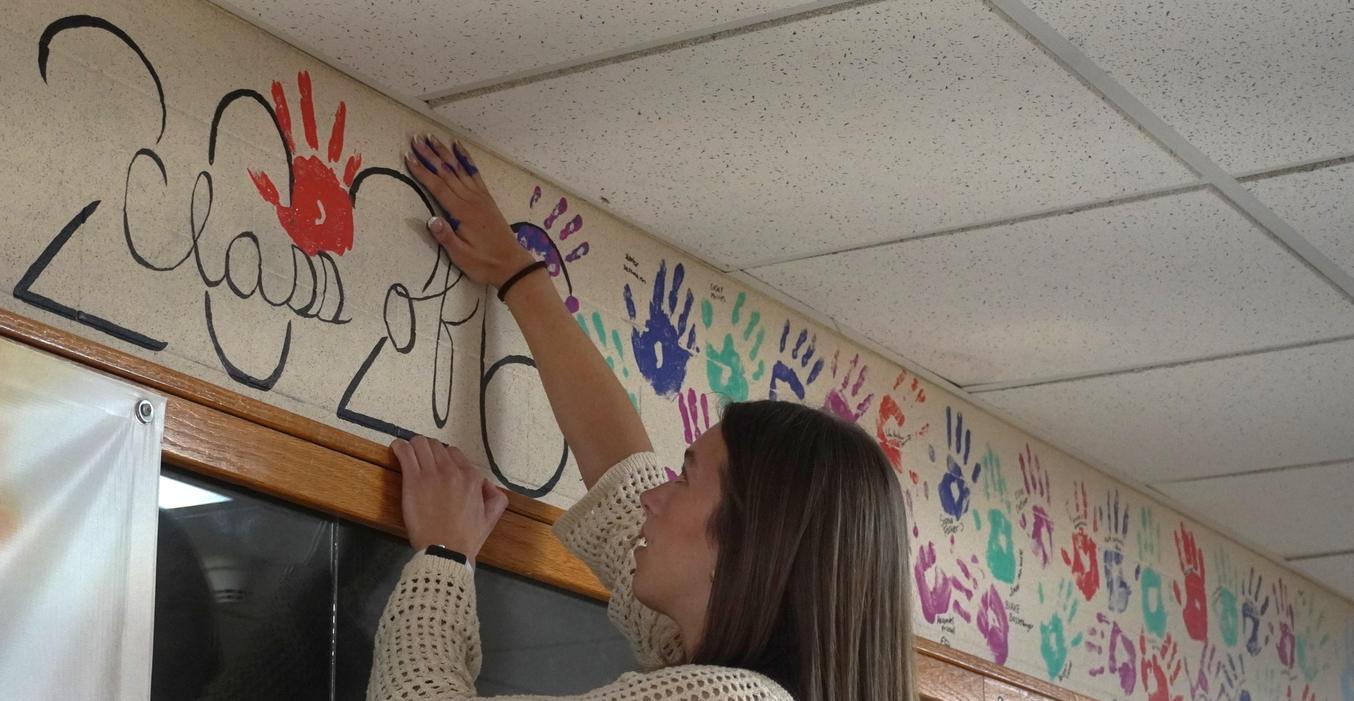 Student adding to handprint mural for Class of 2020.