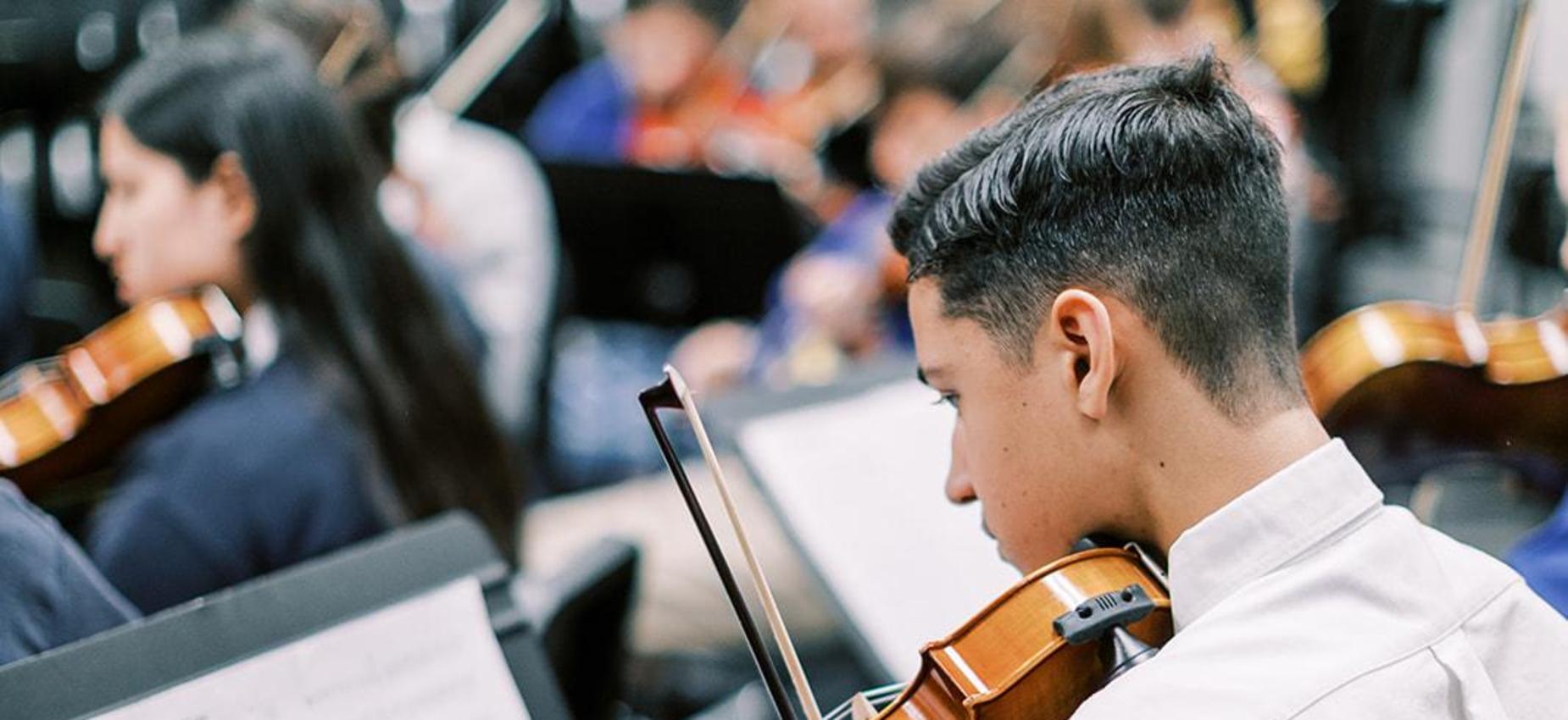 Student plays violin during orchestra class