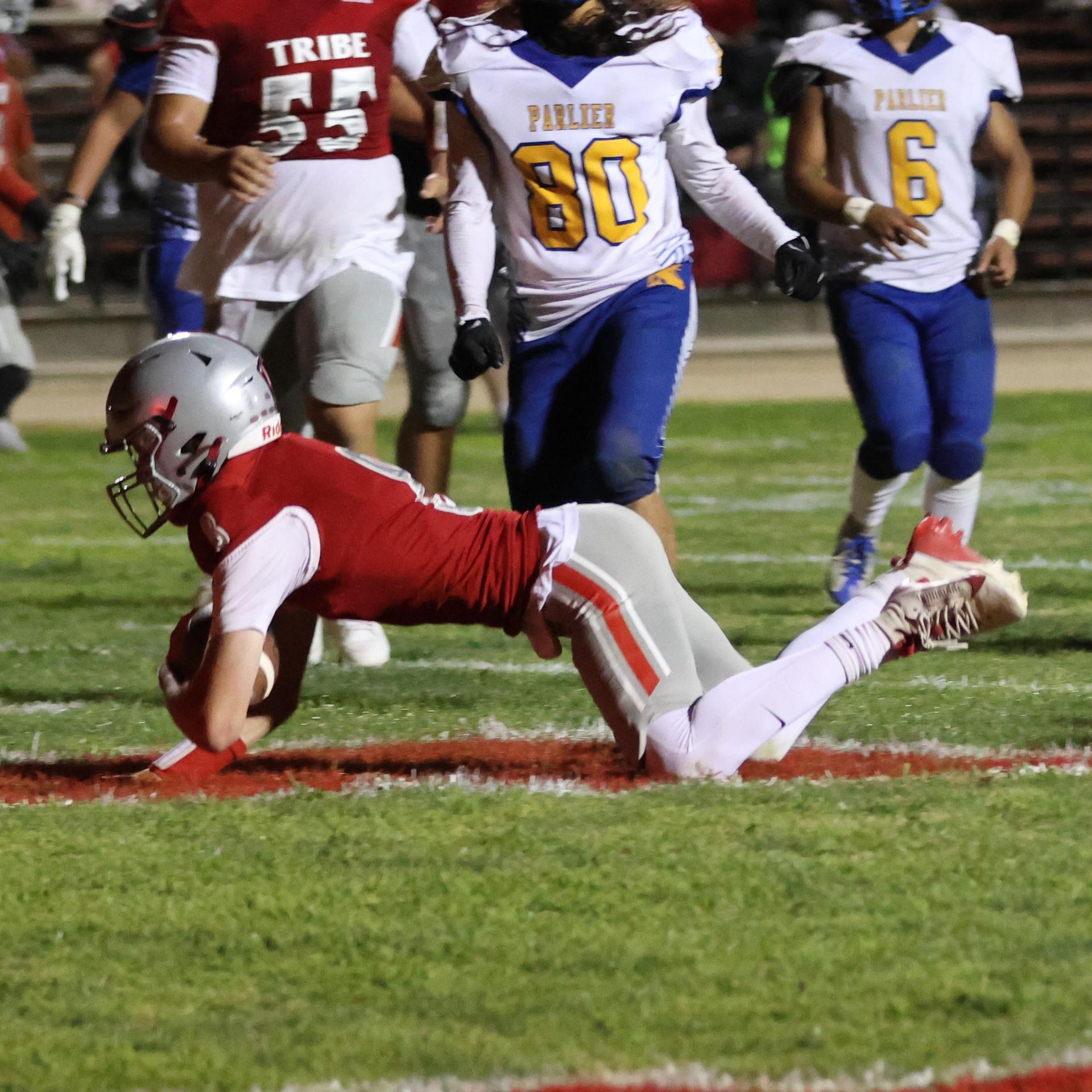 Varsity football players in action against Parlier 70