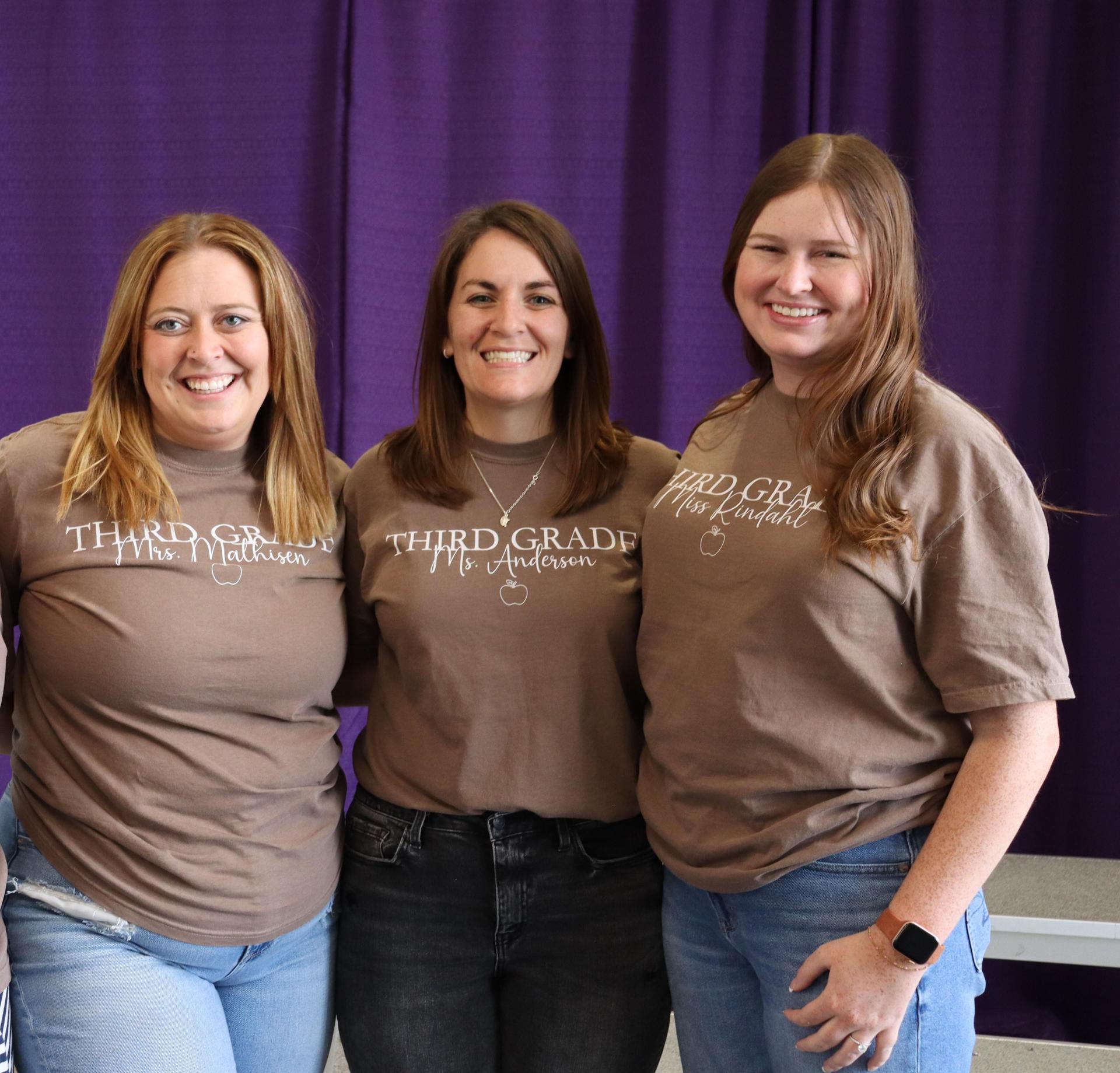  The Third grade teachers, wearing matching shirts and smiling for a picture. 