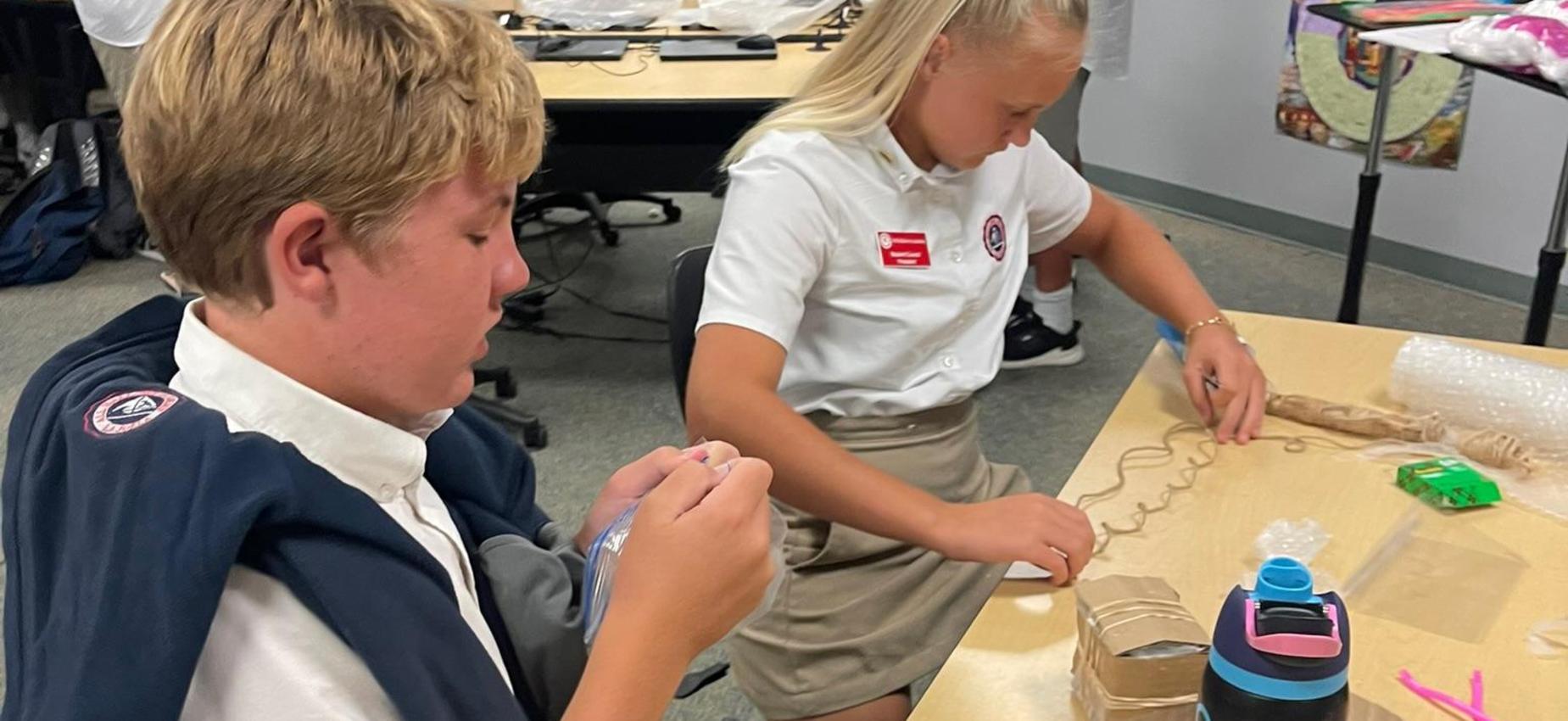 two 8th grade students designing device for egg drop