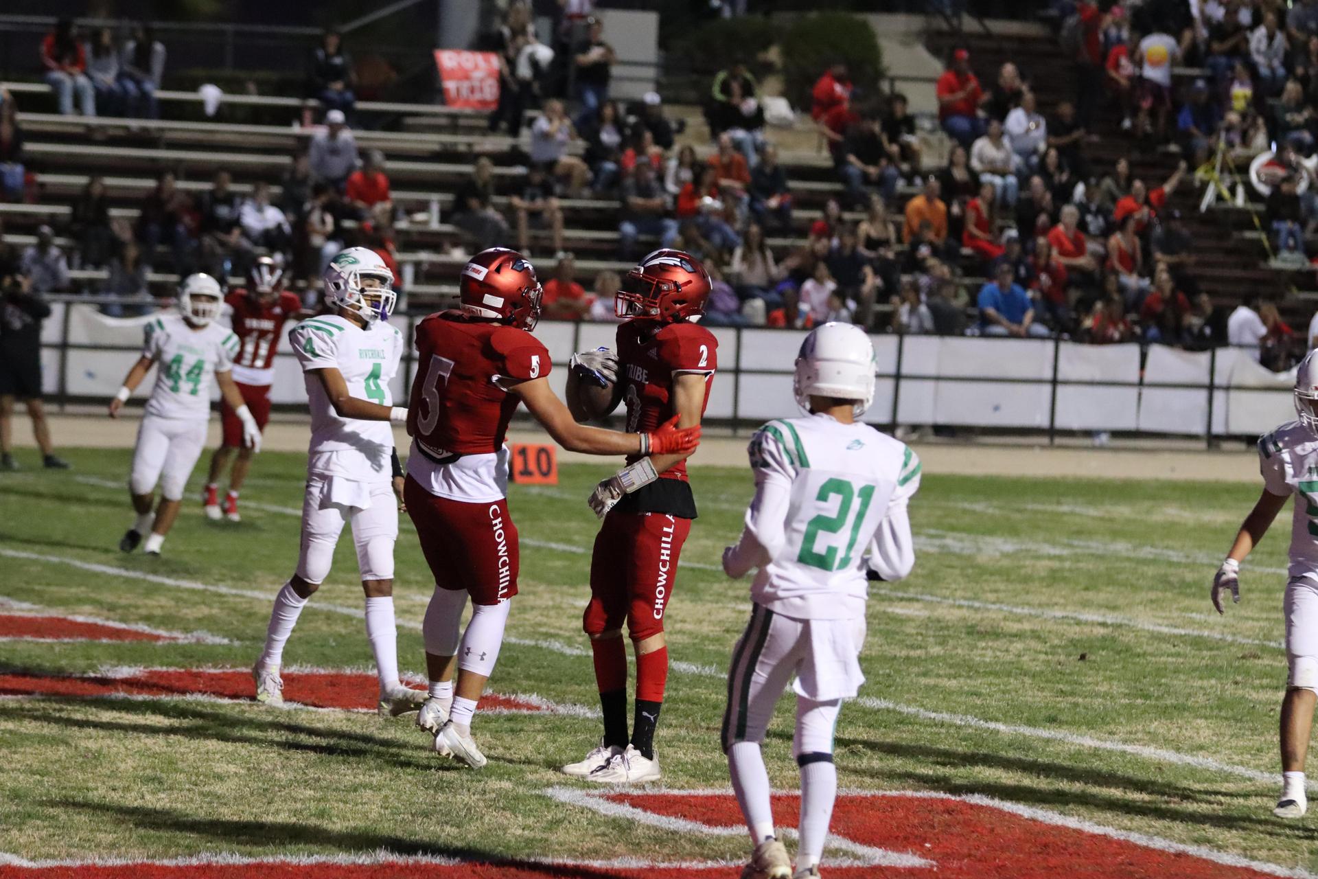 varsity football players in action against Riverdale