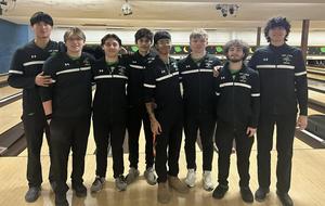 8 male athletes pose for picture with bowling alley as backdrop