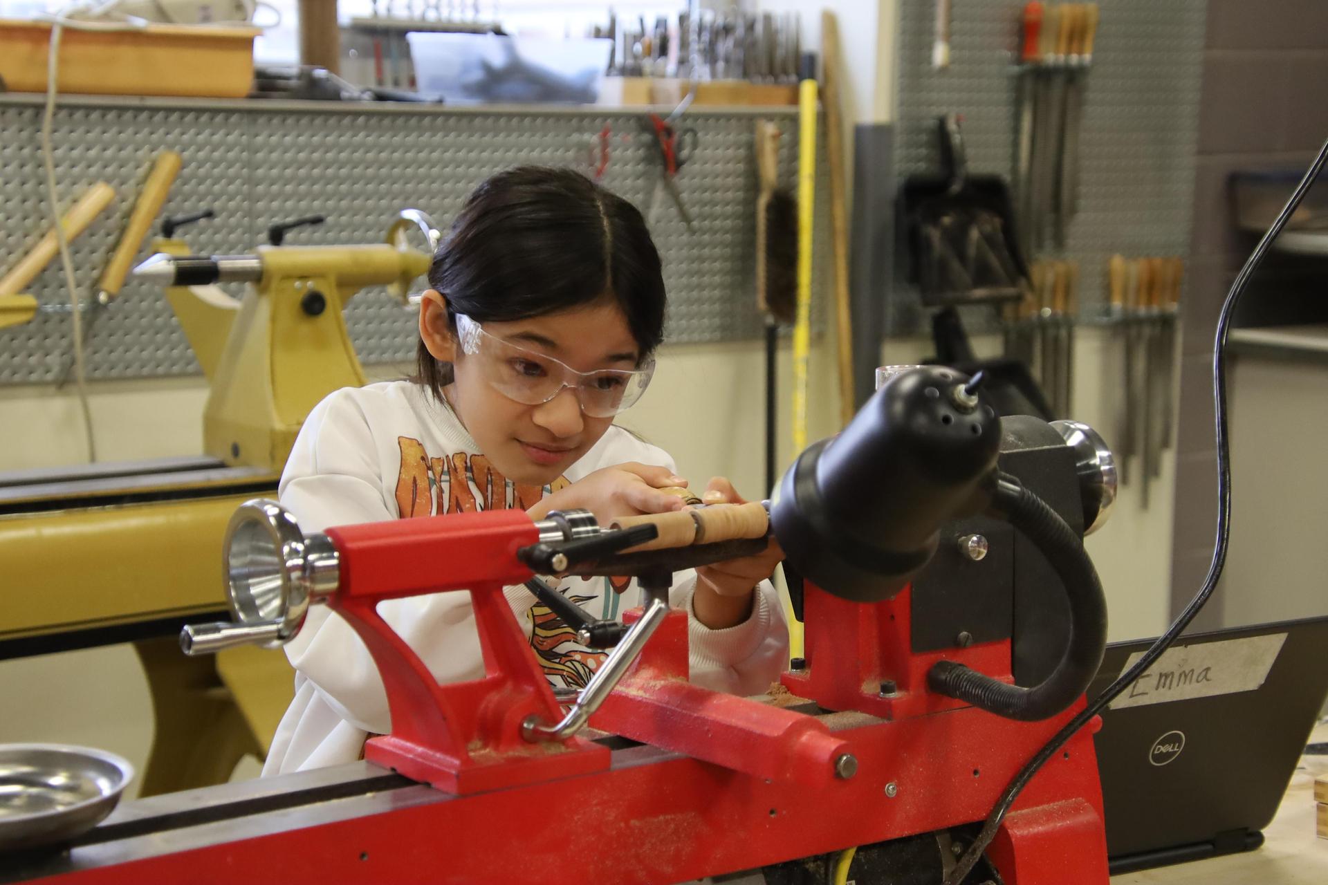 middle school girl working on lathe in shop class