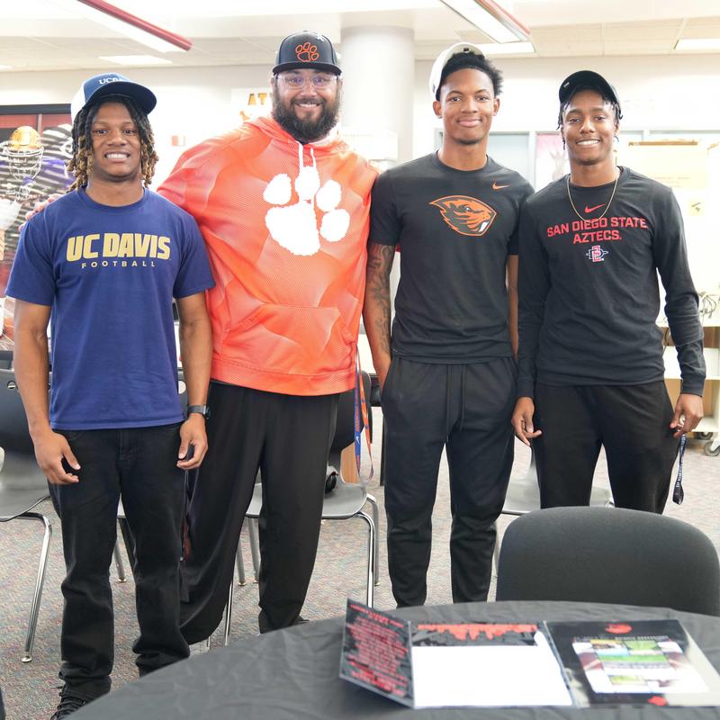 Three early signing Football players with Coach Galliano