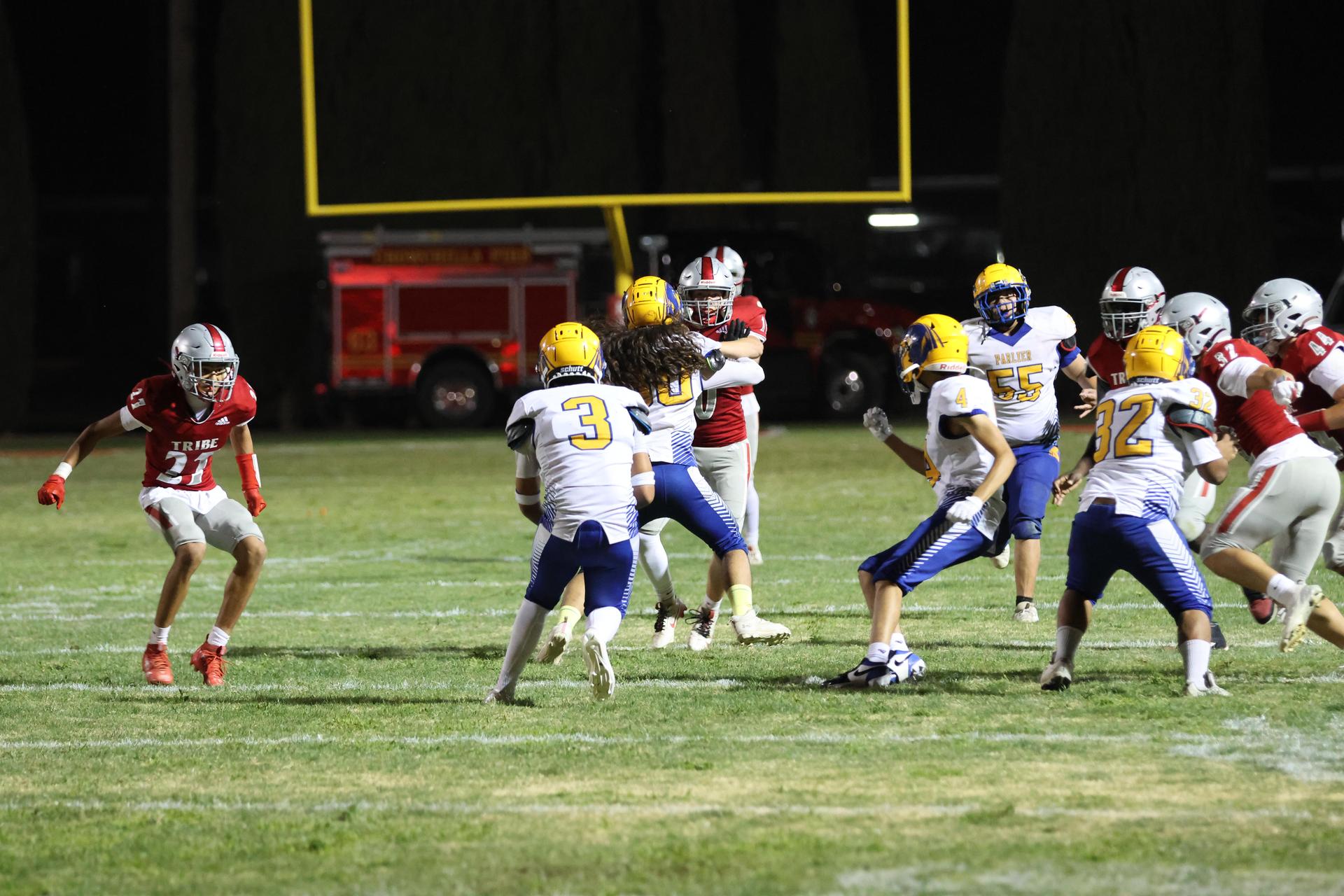 Varsity football players in action against Parlier 95