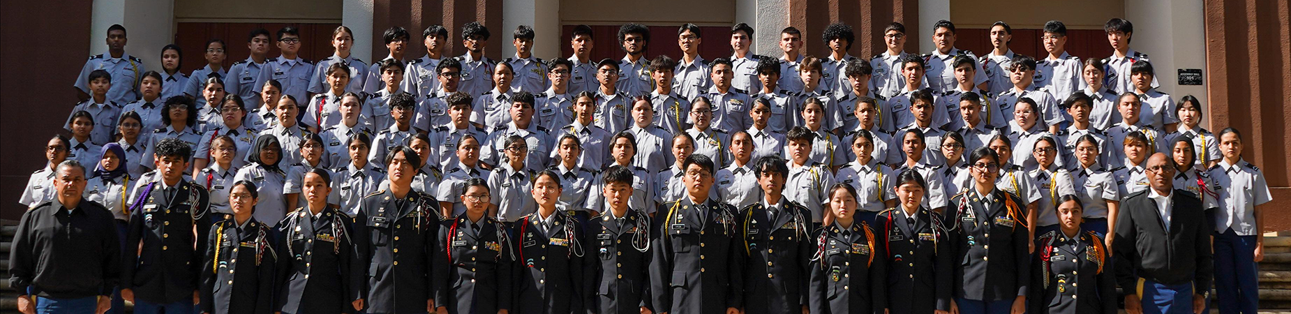 A large group of Junior Reserve Officers' Training Corps cadets standing in front of Van Nuys High School
