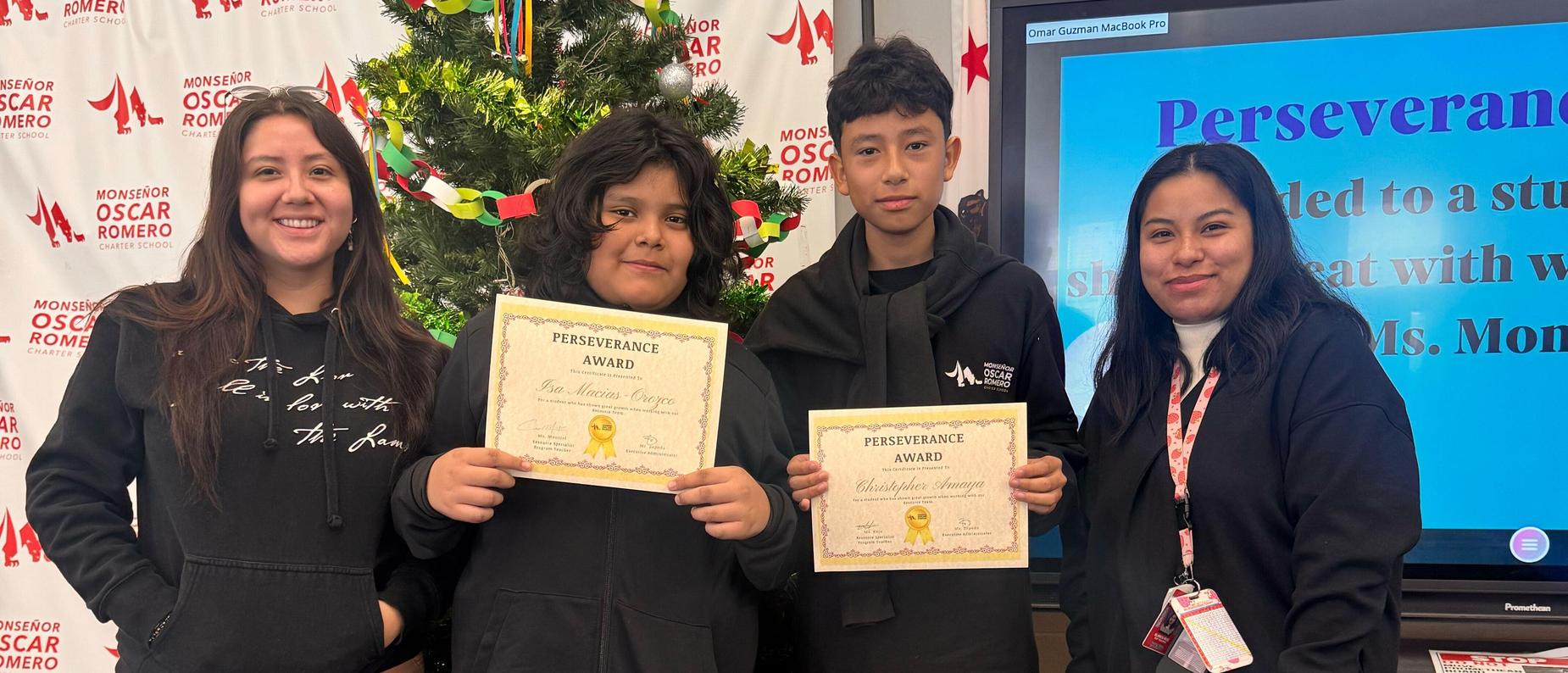 Ms. Montiel and Ms. Ruiz presenting the Perseverance Award to 6th grade scholars