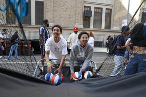 Two young men smiling while playing a basketball shooting game.