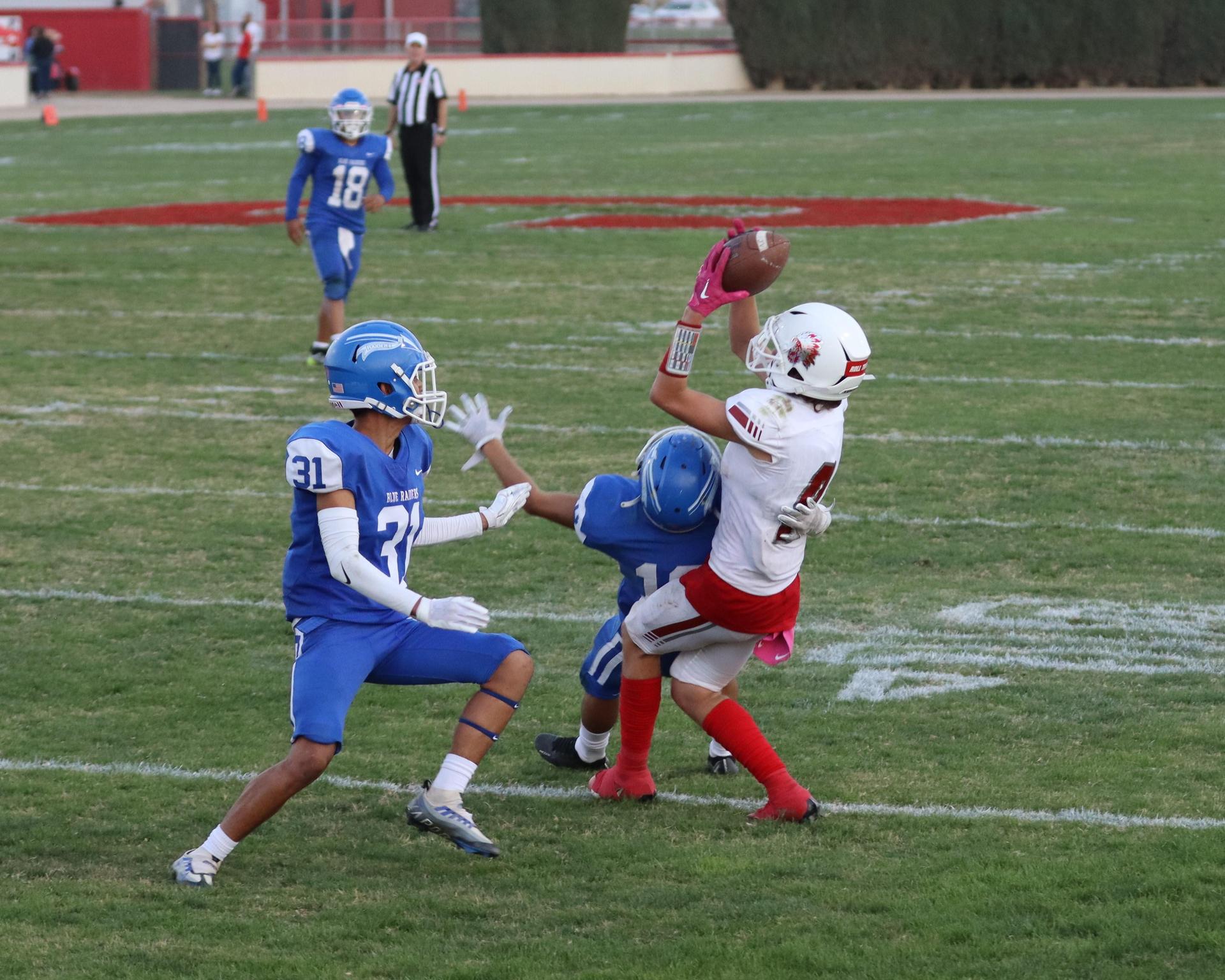 vJunior Varsity football players in action against Caruthers