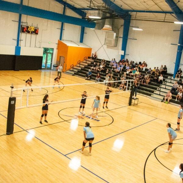 Girls volleyball game inside the home gym
