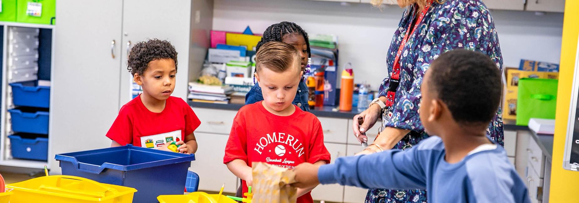 Children engaged in activities with an educator in a classroom setting.