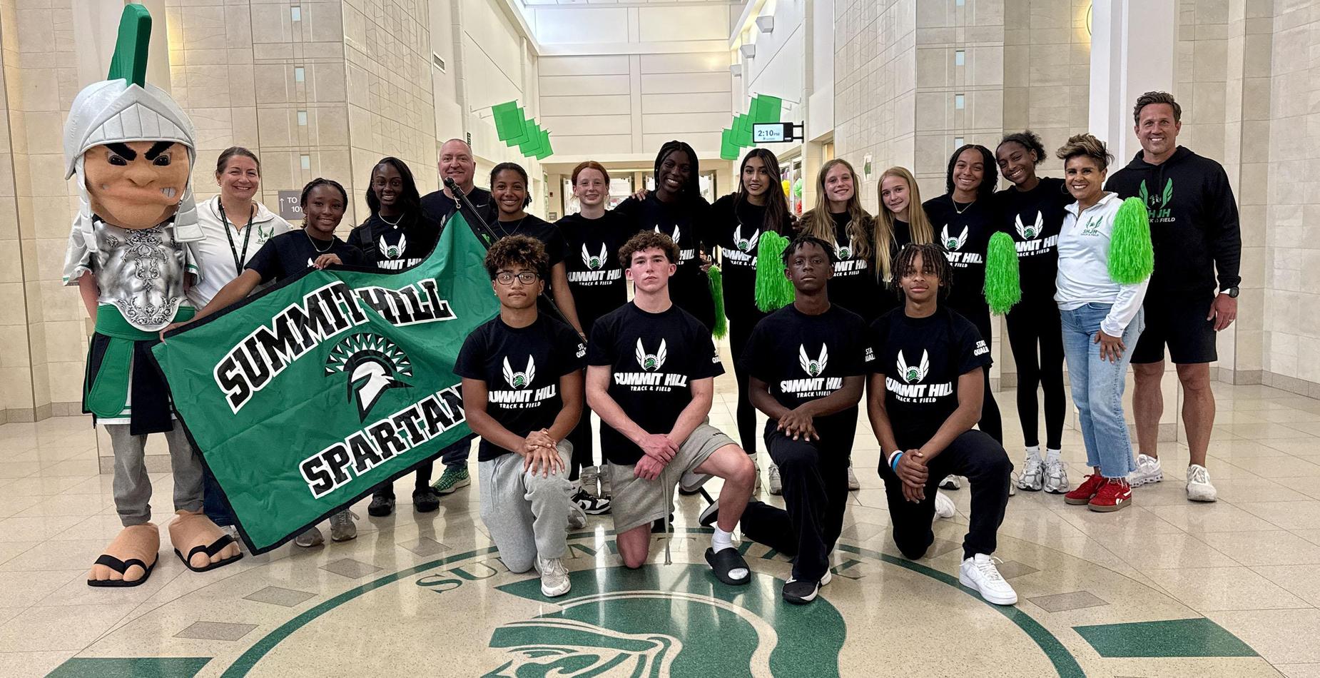 Group photo of the Summit Hill Junior High student-athletes who qualified for the IESA 4A State Track and Field Meet and the team's coaches taken inside the school's main entrance.