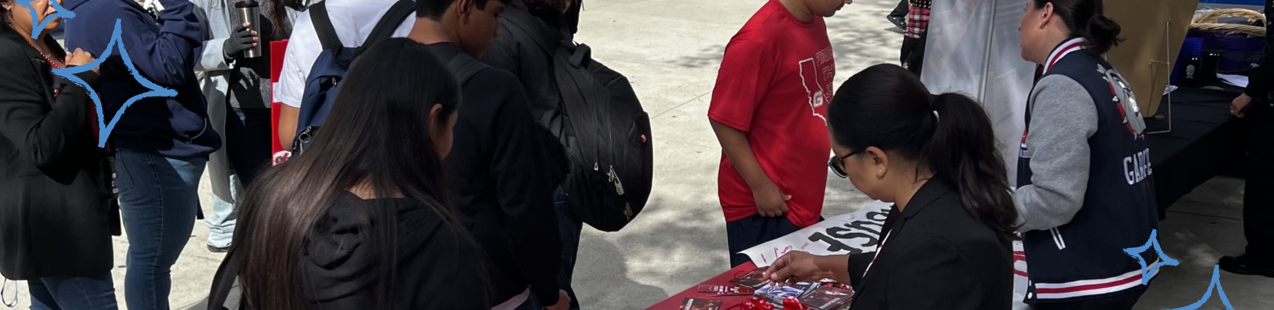 students in a crowd around a resource table