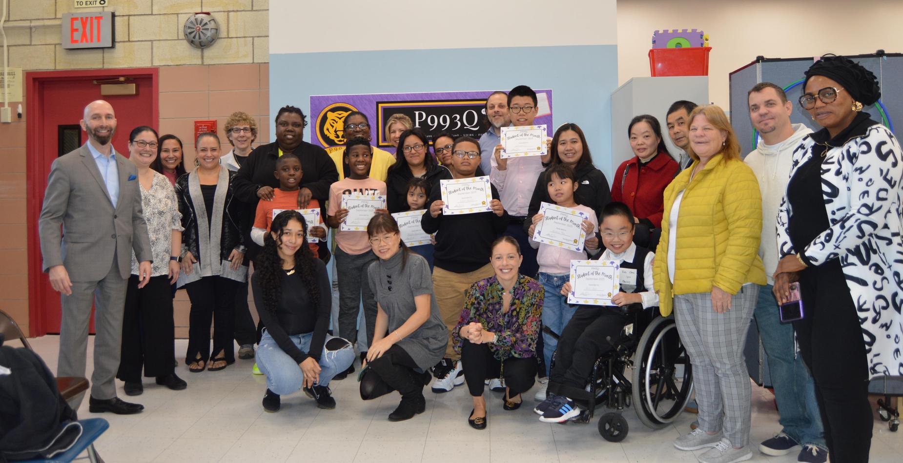 A diverse group of students and staff celebrating student of the month!