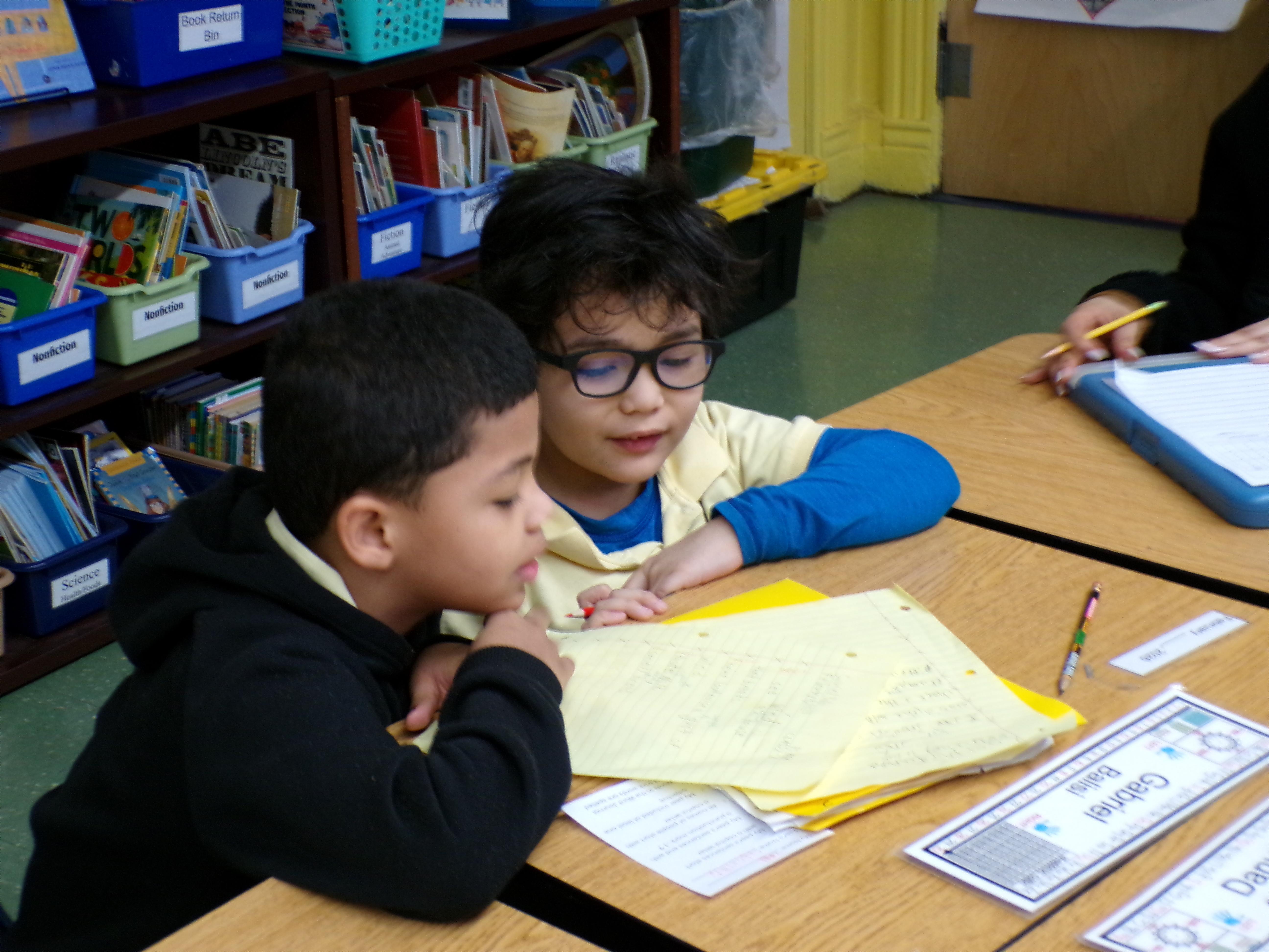 two students working on writing